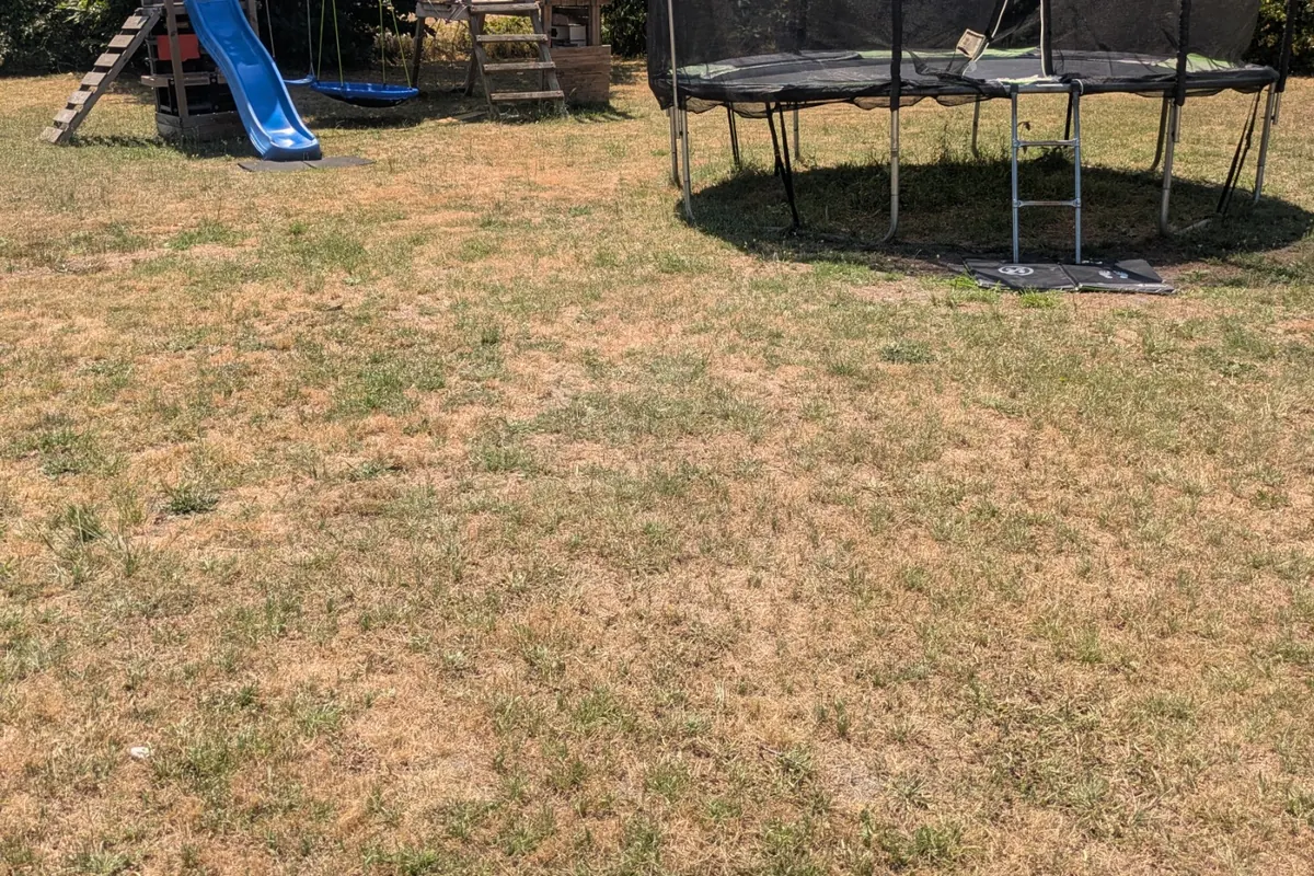 Jardin mutualisé avec trampoline et jeux au gîte Le Loumama