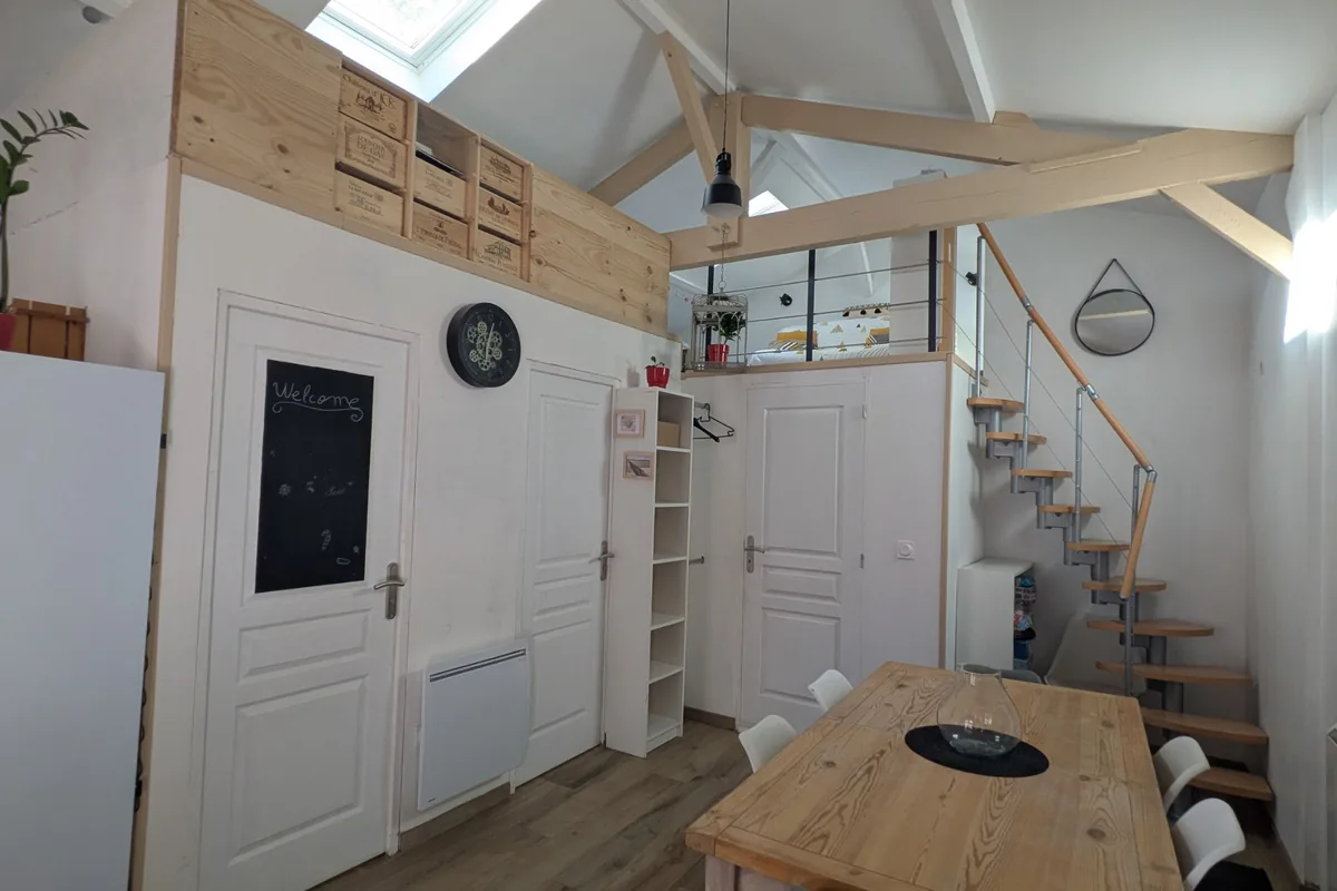 Espace de vie ouvert avec salon, coin repas et belle hauteur sous plafond